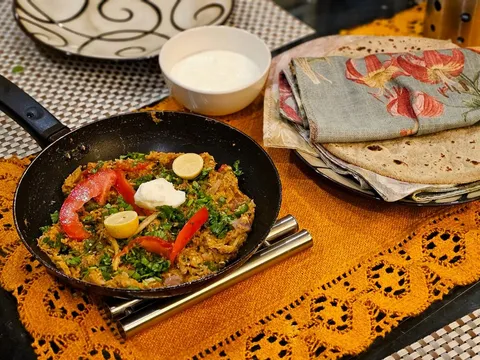 A bowl of smoky baingan bharta garnished with coriander