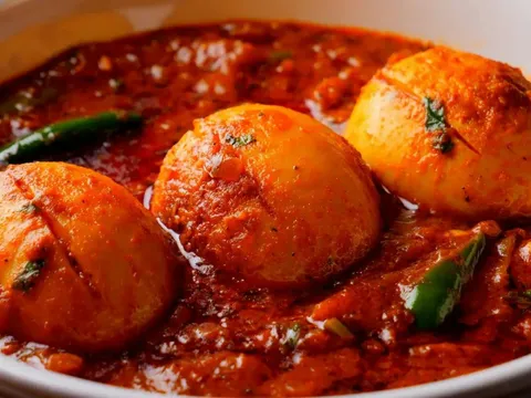 A bowl of egg curry with boiled eggs in a spiced gravy
