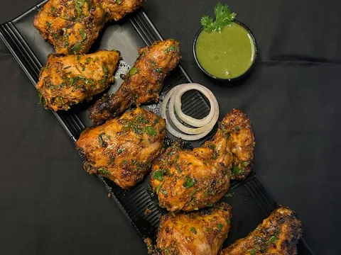 Baked tandoori chicken pieces with a wedge of lemon