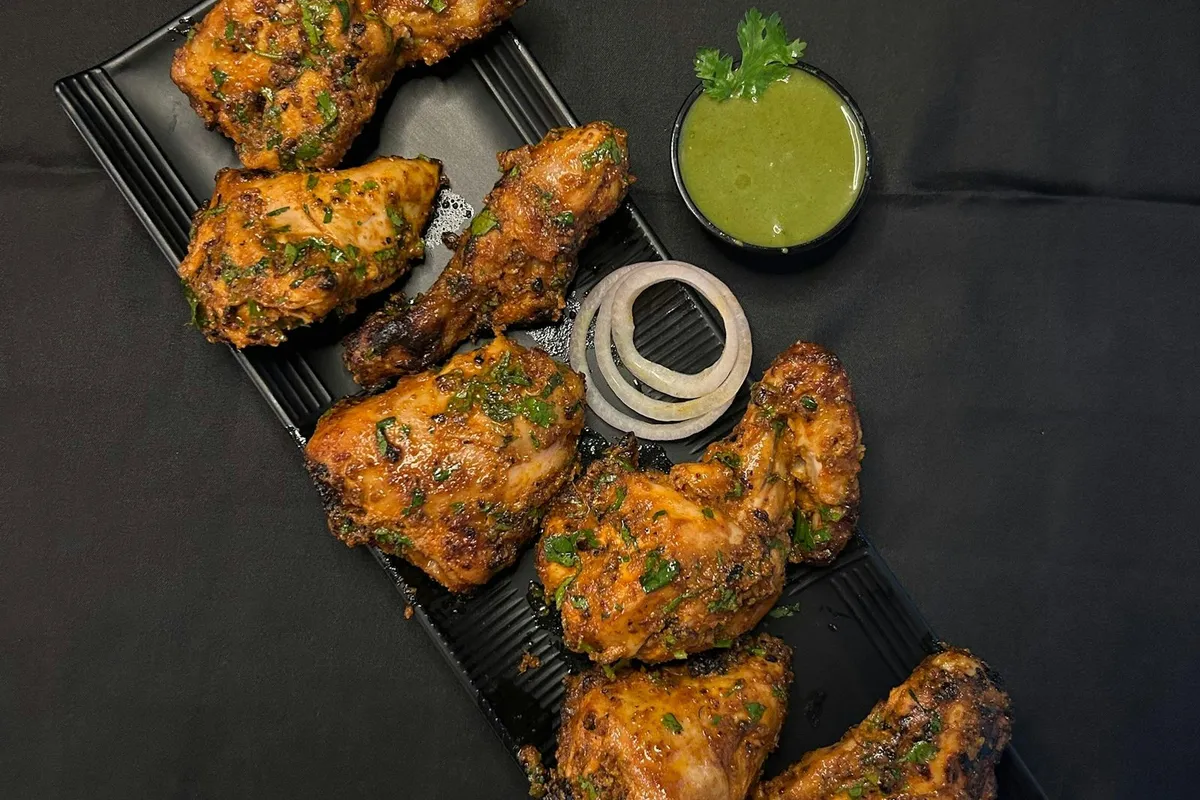 Baked tandoori chicken pieces with a wedge of lemon